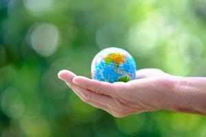zakelijke hand met earth globe op groene achtergrond