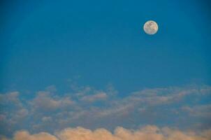 de maan is gezien in de blauw lucht met wolken foto