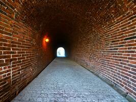 de rood steen muur met een groot steen tunnel foto