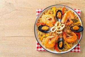 zeevruchtenpaella met garnalen, kokkels, mosselen op saffraanrijst foto