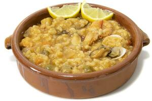 rijst- met zeevruchten, geserveerd in een klei schaal. geïsoleerd Aan wit achtergrond. Spaans voedsel concept. foto