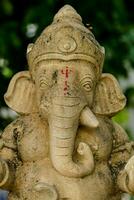 een standbeeld van een olifant met rood dots Aan haar gezicht foto