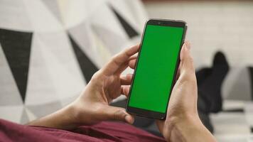 persoon Holding een mobiel telefoon met een groen scherm, klaar naar vervangen het met ieder inhoud foto