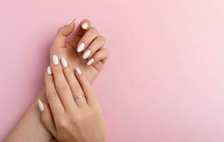 handen van een mooi goed verzorgd vrouw met vrouwelijk nagels Aan een roze achtergrond. manicure foto