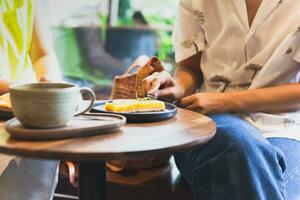 vrouw aan het eten citroen taart scherp taart met koffie Aan tafel. foto