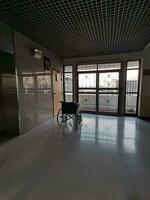 de rolstoel in de midden- van een leeg gang in de ziekenhuis foto