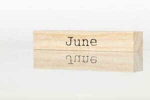 een houten kubus met de opschrift juni Aan een wit achtergrond foto