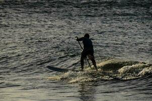 een Mens is rijden een surfboard in de oceaan foto