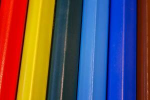 reeks van gekleurde pastel potloden in rij multi kleur in het formulier van Gesloten rits en potlood slijper foto