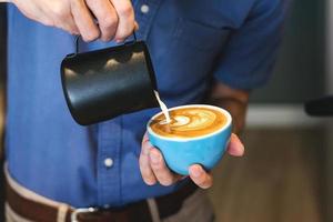 barista maakt koffie latte art in een coffeeshop foto