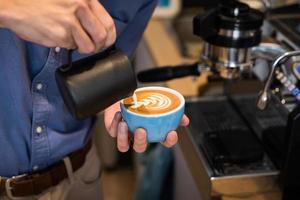 barista maakt koffie latte art in een coffeeshop foto