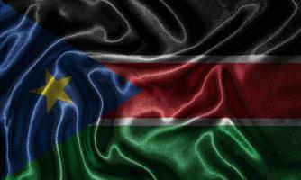 behang met vlag van Zuid-Soedan en wapperende vlag per stof. foto