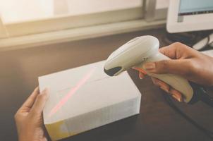 een menselijke hand met pakket met barcodelezer voor levering. foto