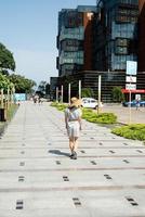 vrouw loopt langs het moderne appartementencomplex met groene lanen foto