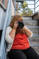 portret van een vrouw met overgewicht die buiten foto's maakt met een camera foto