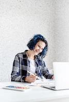 ontwerper aan het werk met kleurenpaletten en laptop in haar studio foto