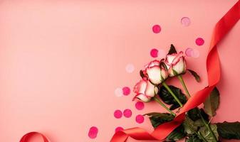 roze rozen met confetti op effen roze achtergrond foto