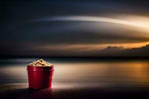 een rood emmer van popcorn Aan de strand Bij zonsondergang. ai-gegenereerd foto