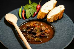 traditioneel Hongaars voedsel rundvlees goulash met brood een pittig paprika's foto