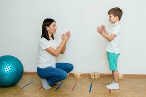 aantrekkelijk vrouw toespraak therapeut geeft les kind naar uitspreken geluiden en woorden correct in kantoor foto