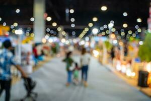 wazig afbeeldingen van handel beurzen in de groot hal. beeld van mensen wandelen Aan een handel eerlijk tentoonstelling of expo waar bedrijf mensen tonen innovatie werkzaamheid en Cadeau producten in een groot hal. foto