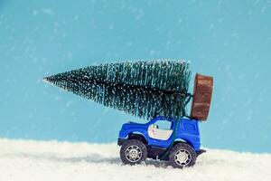 Kerstmis boom Aan speelgoed- auto rit over- sneeuw foto