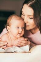 mooi moeder zoenen haar weinig baby dochter foto