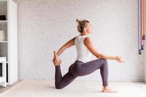 blonde vrouw die thuis yoga beoefent foto