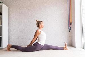 jonge aantrekkelijke vrouw die yoga beoefent, sportkleding draagt