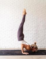 jonge aantrekkelijke vrouw die yoga beoefent, sportkleding draagt foto