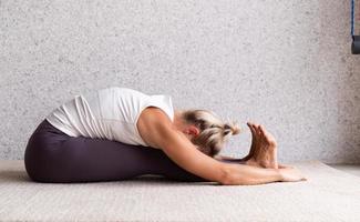 jonge aantrekkelijke vrouw die yoga beoefent, sportkleding draagt foto