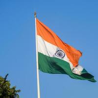 indiase vlag hoog op connaught plaats met trots in blauwe lucht, indiase vlag wapperen, indiase vlag op onafhankelijkheidsdag en republiek dag van india, tilt-up shot, wuivende indische vlag, har ghar tiranga foto