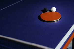 tafel tennis racket Aan de blauw ping pong tafel foto