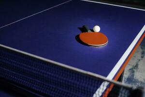 tafel tennis racket Aan de blauw ping pong tafel foto