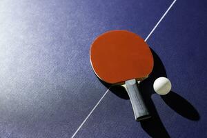 tafel tennis racket Aan de blauw ping pong tafel foto