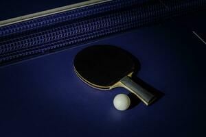 tafel tennis racket Aan de blauw ping pong tafel foto