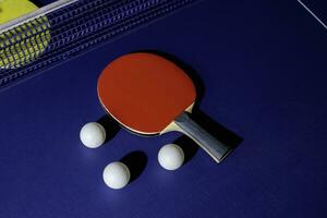tafel tennis racket Aan de blauw ping pong tafel foto