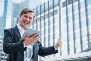 jonge zakenman voelt zich gelukkig met tablet