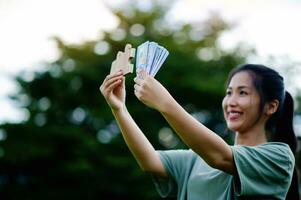 dollar in de handen van een Aziatisch vrouw besparingen, investeringen, salaris, inkomen, contant geld stromen, geluk en financieel succes en investeringen. foto