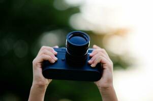 nemen afbeeldingen met een spiegelloos camera. weinig meisje beoefenen natuur fotografie weinig fotograaf de vreugde van nemen afbeeldingen foto