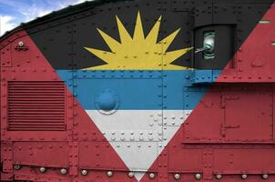 antigua en Barbuda vlag afgebeeld Aan kant een deel van leger gepantserd tank detailopname. leger krachten conceptuele achtergrond foto