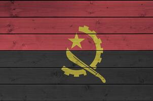 Angola vlag afgebeeld in helder verf kleuren Aan oud houten muur. getextureerde banier Aan ruw achtergrond foto