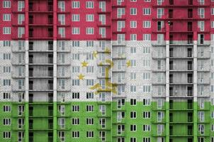 Tadzjikistan vlag afgebeeld in verf kleuren Aan meerdere verdiepingen woonachtig gebouw onder bouw. getextureerde banier Aan steen muur achtergrond foto