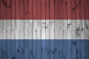 Nederland vlag afgebeeld in helder verf kleuren Aan oud houten muur. getextureerde banier Aan ruw achtergrond foto