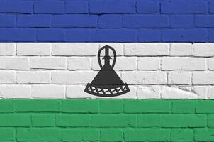 Lesotho vlag afgebeeld in verf kleuren Aan oud steen muur. getextureerde banier Aan groot steen muur metselwerk achtergrond foto