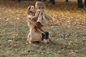 moeder en haar dochter hebben plezier en wandelen in het herfstpark. foto