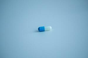 1 blauw Wit capsule Aan een wit achtergrond, medisch concept. foto