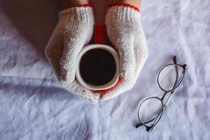 rode koffiekop in de hand met handschoenen in de winter foto