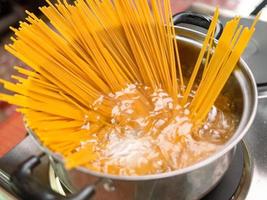 rauwe spaghetti wordt gekookt in kokend water