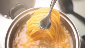 rauwe spaghetti wordt gekookt in kokend water. foto